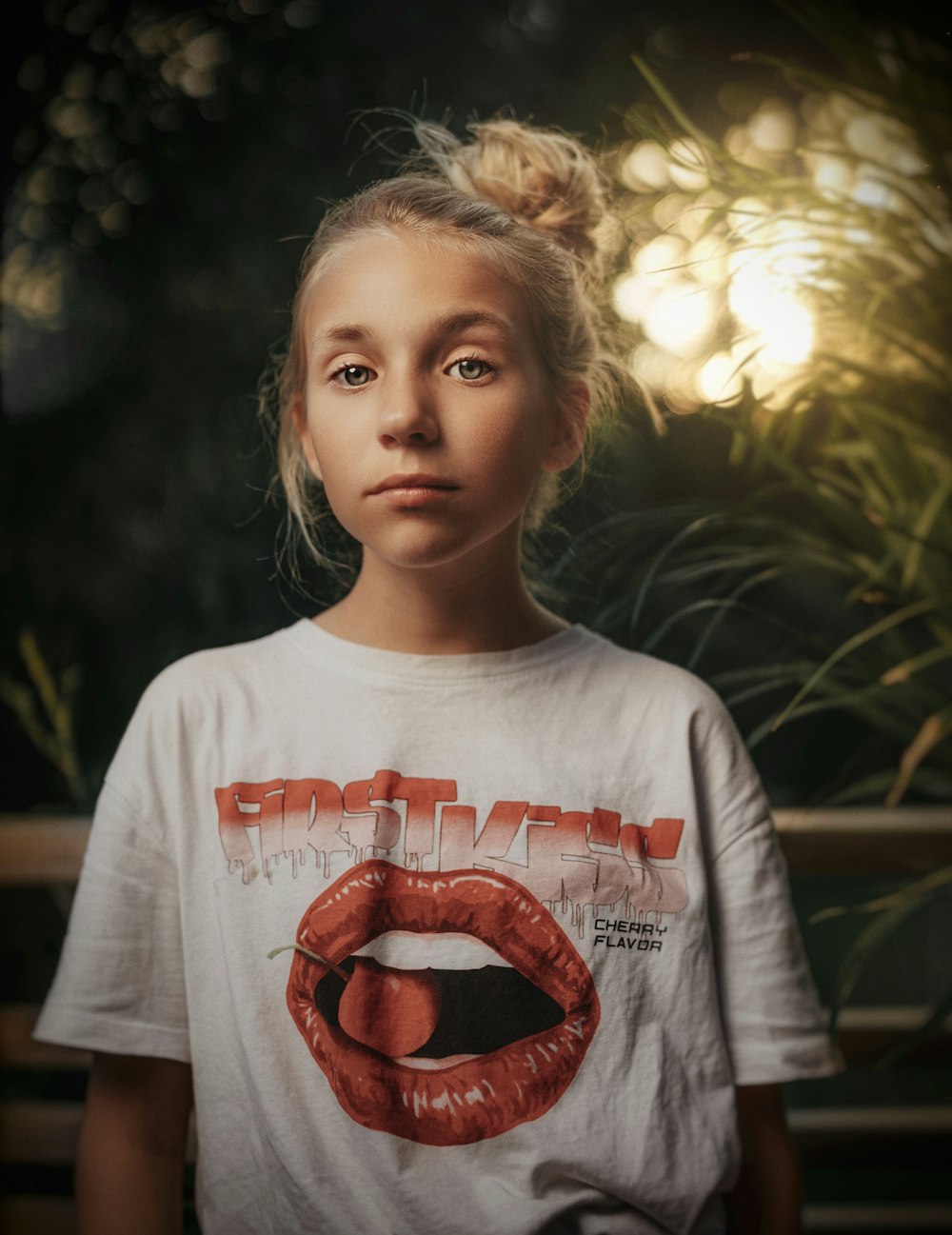 girl in white and red crew neck long sleeve shirt standing near green leaf plant during