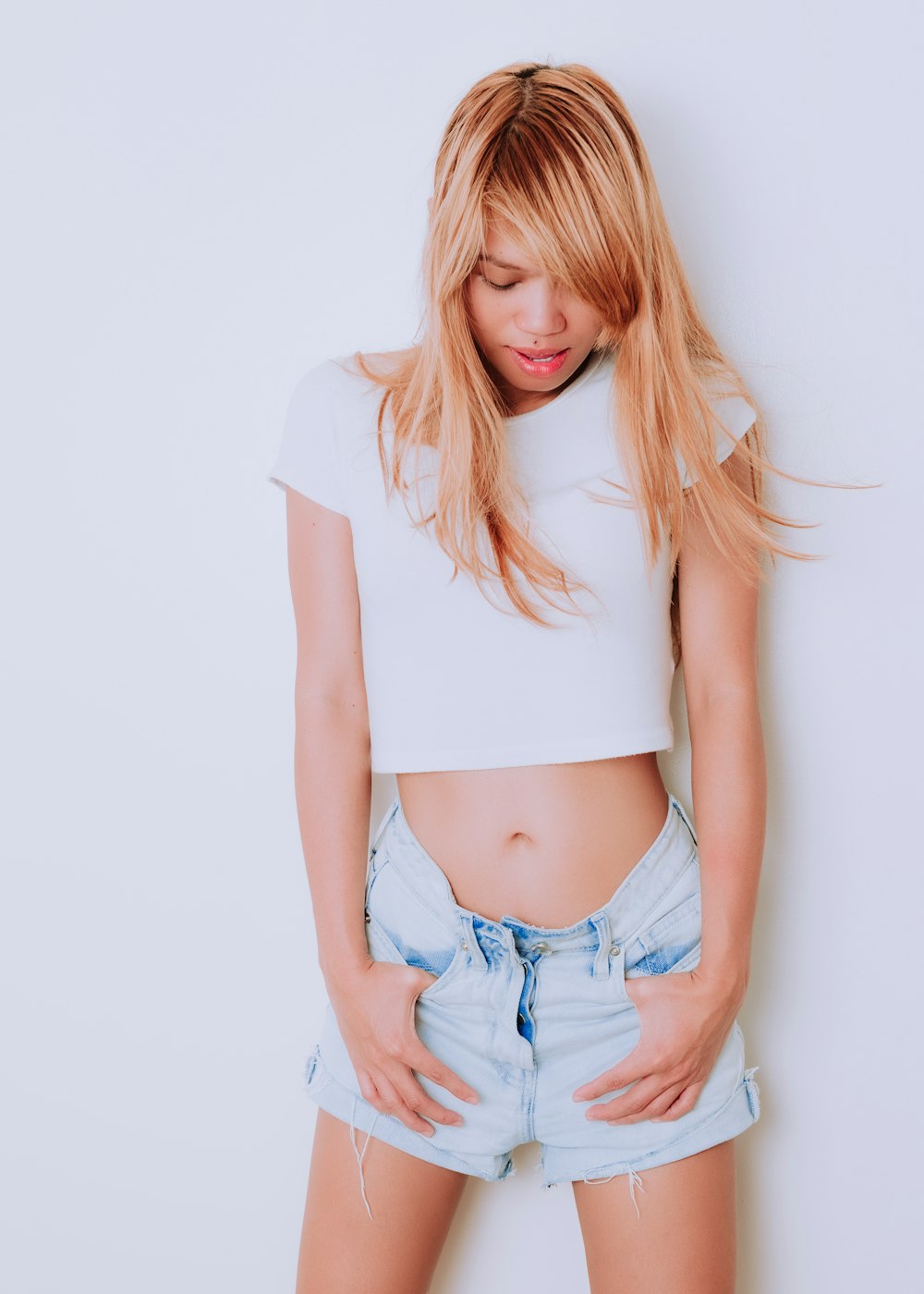 woman in white crop top and blue denim shorts