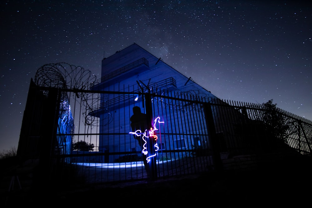 man in red jacket standing near building during night time