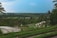 A panoramic view of lush green rice terraces under a clear blue sky.