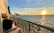 A cozy seaside apartment balcony overlooking the calm Mediterranean waters at sunset.