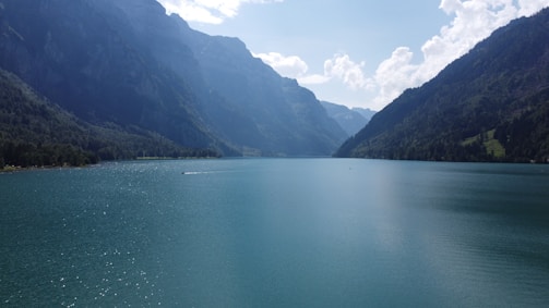 A serene mountain lake reflecting towering peaks under a clear blue sky.