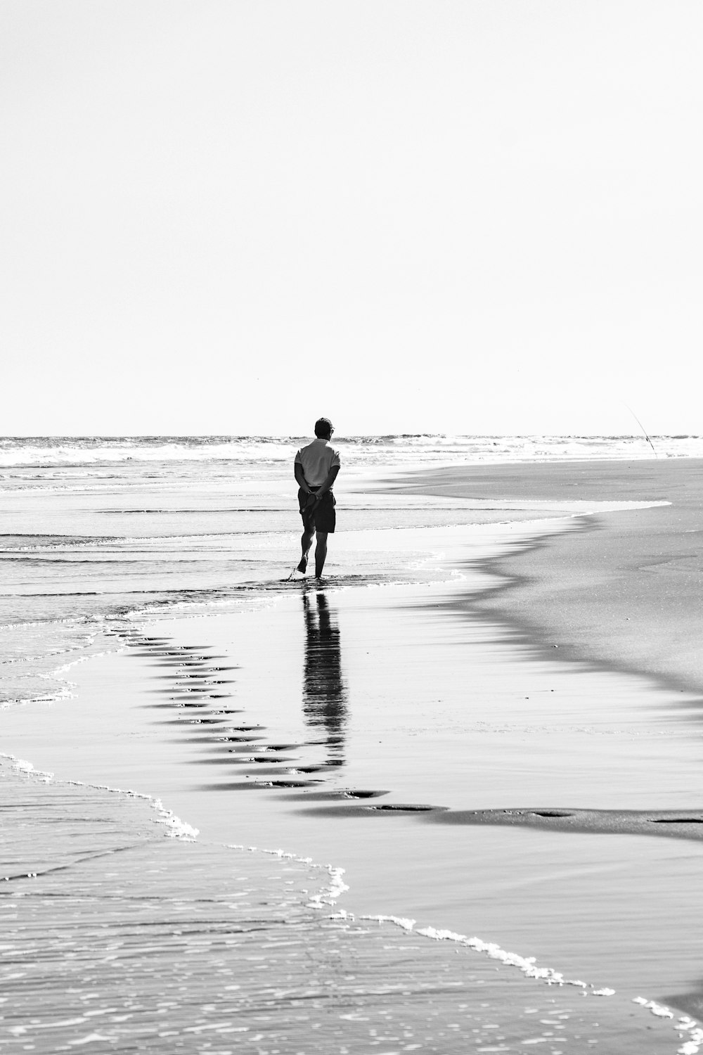 Mann, der tagsüber am Strand spazieren geht