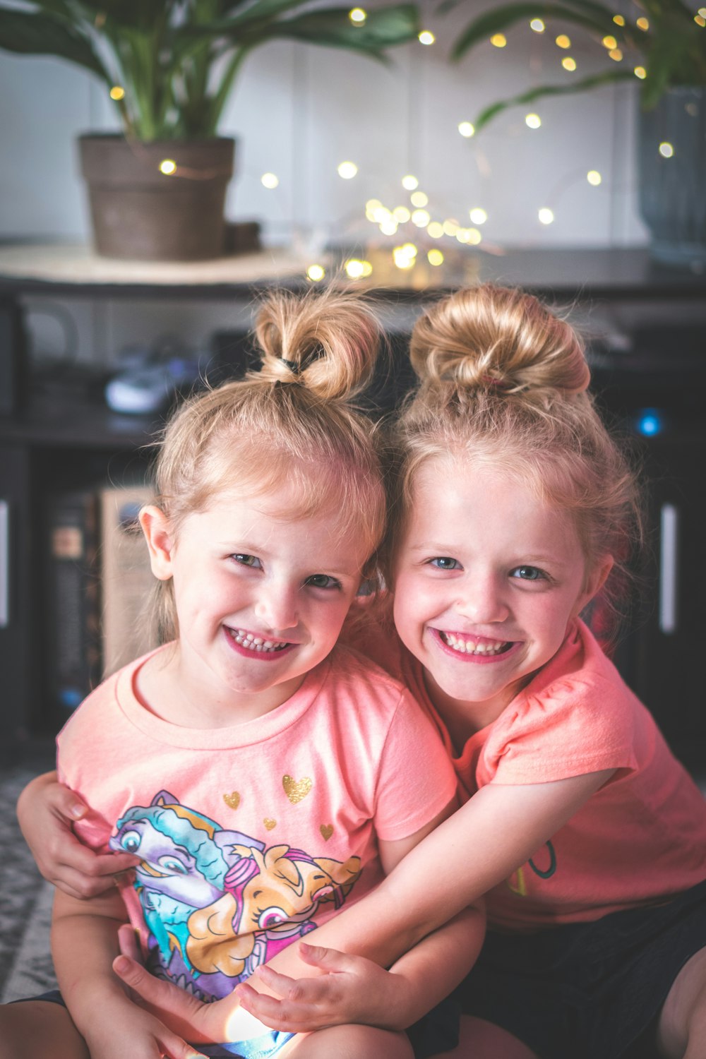 girl in pink crew neck t-shirt smiling beside girl in pink t-shirt