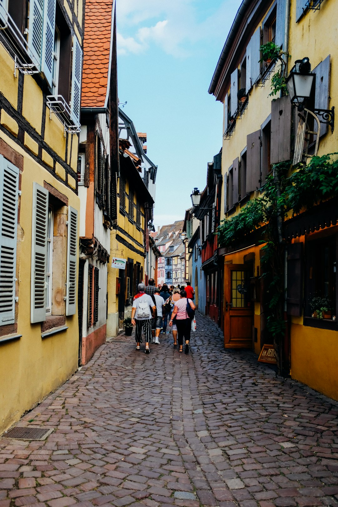 people walking on street between buildings during daytime