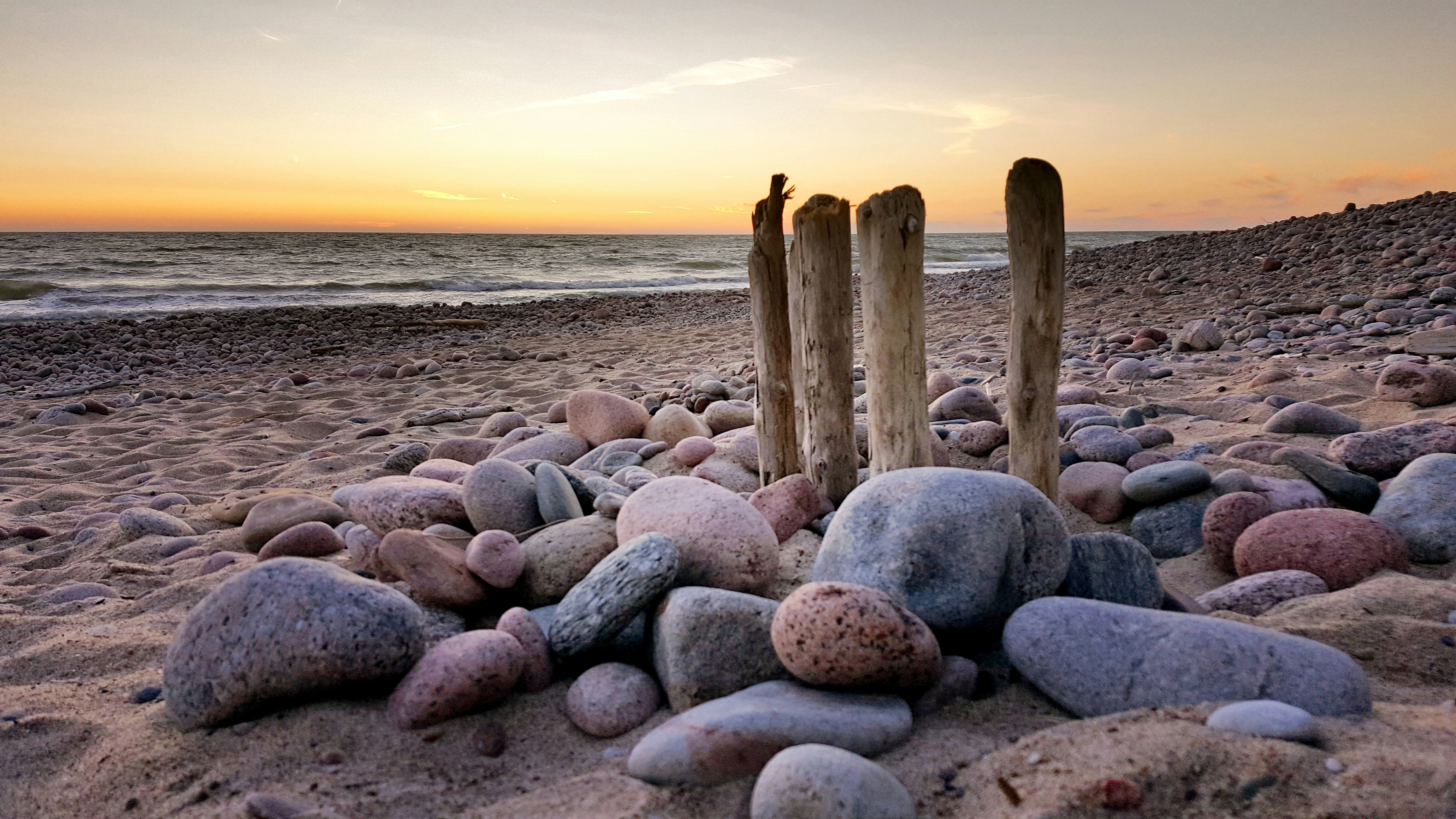 brauner Holzstab am Strand während des Sonnenuntergangs