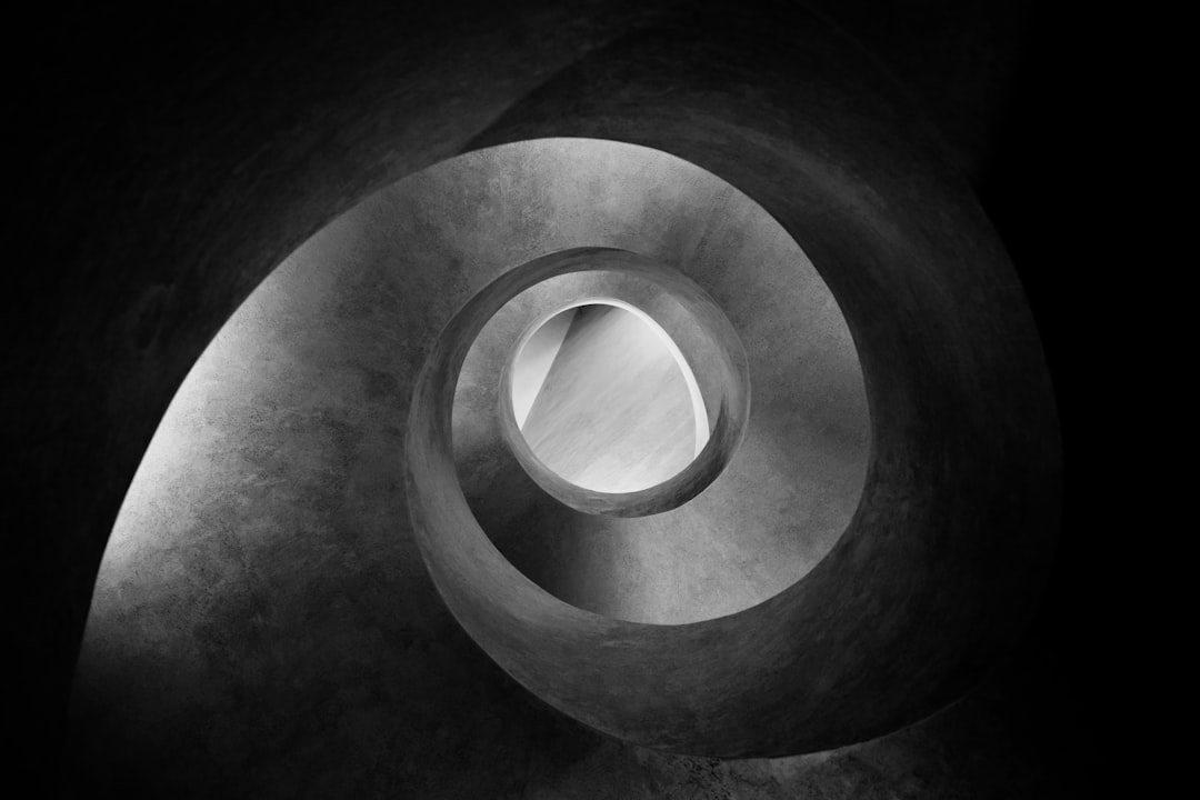 grayscale photo of spiral tunnel