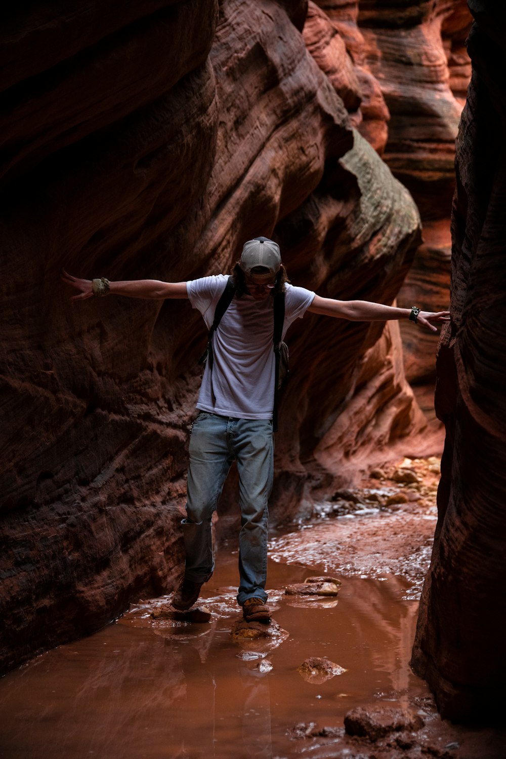 a man standing in a narrow slot in a canyon