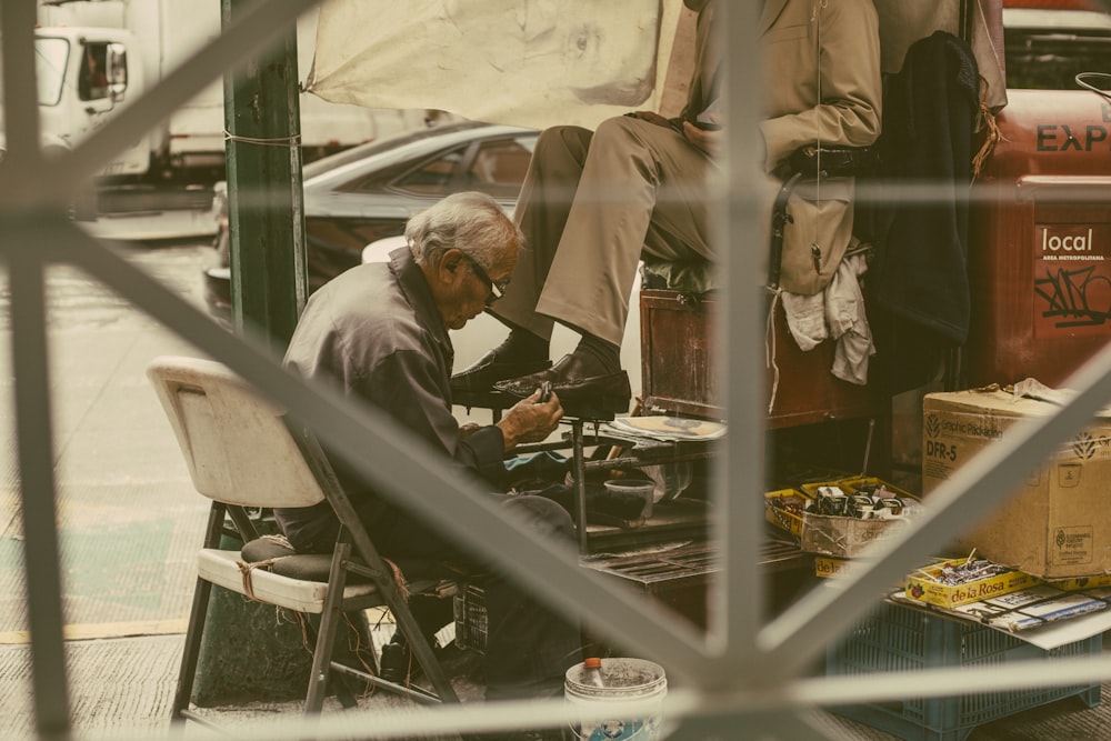 man in gray thobe sitting on white chair