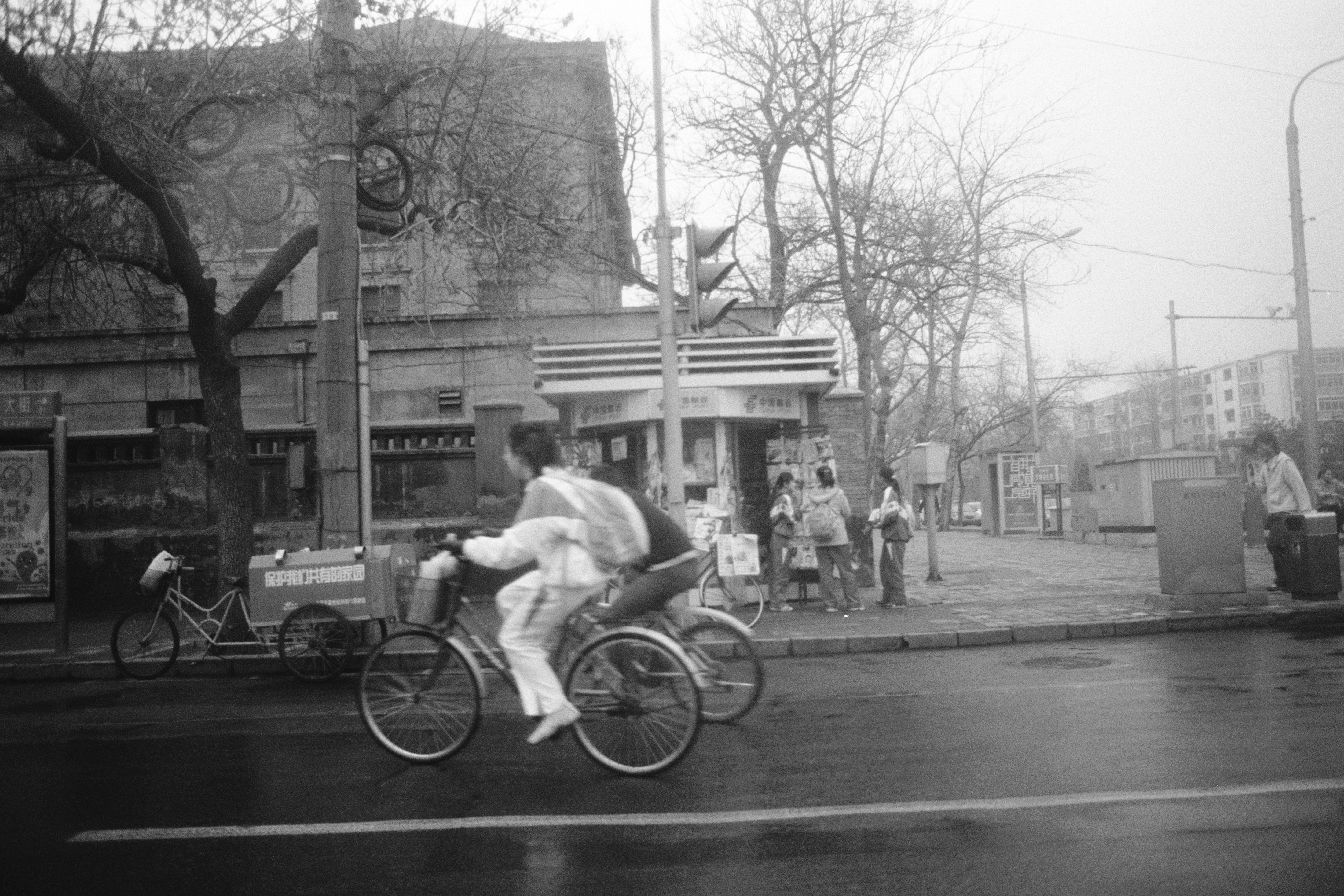 grayscale photo of man riding bicycle on road