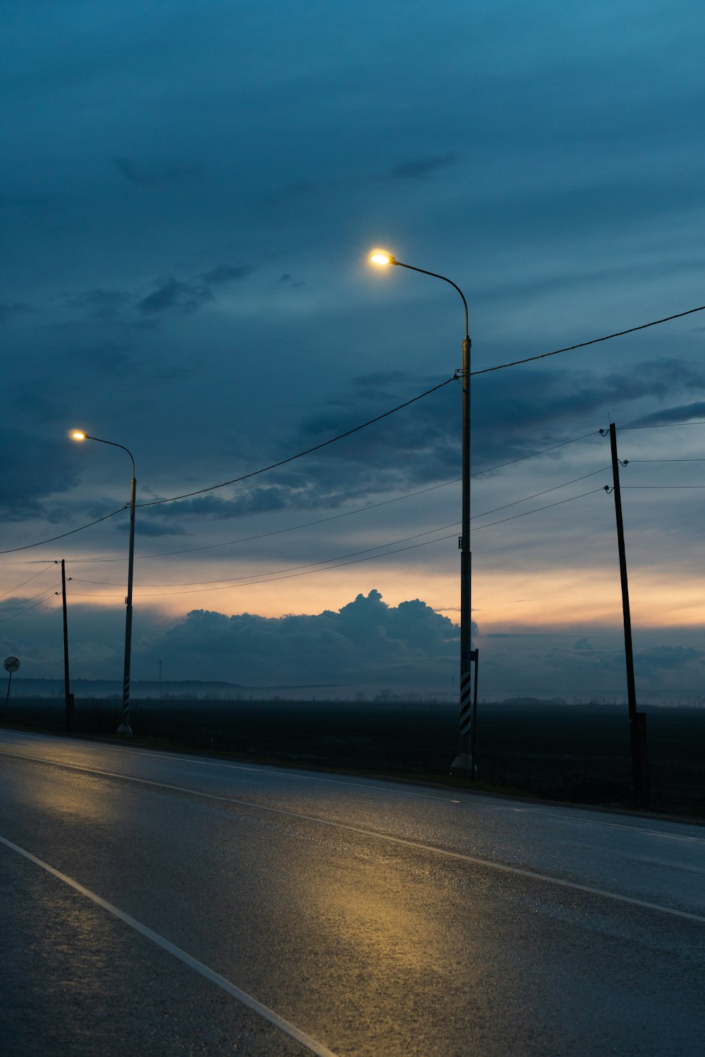 black asphalt road near body of water during sunset