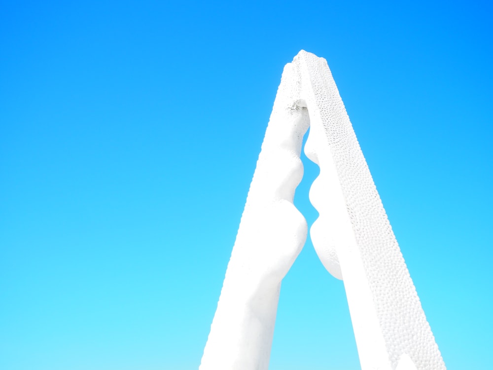 a tall white monument with a blue sky in the background