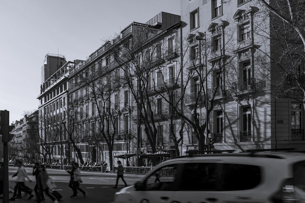 people walking on street near white concrete building during daytime