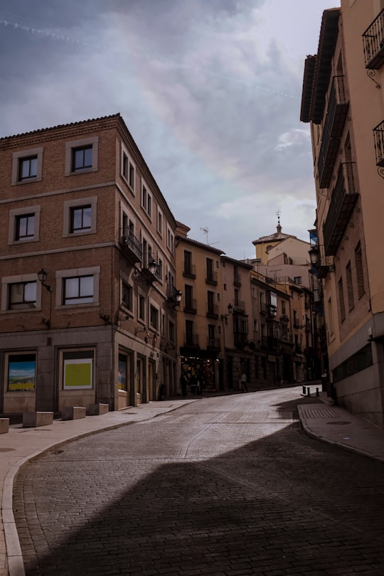 brown concrete building under cloudy sky during daytime in Toledo Spain