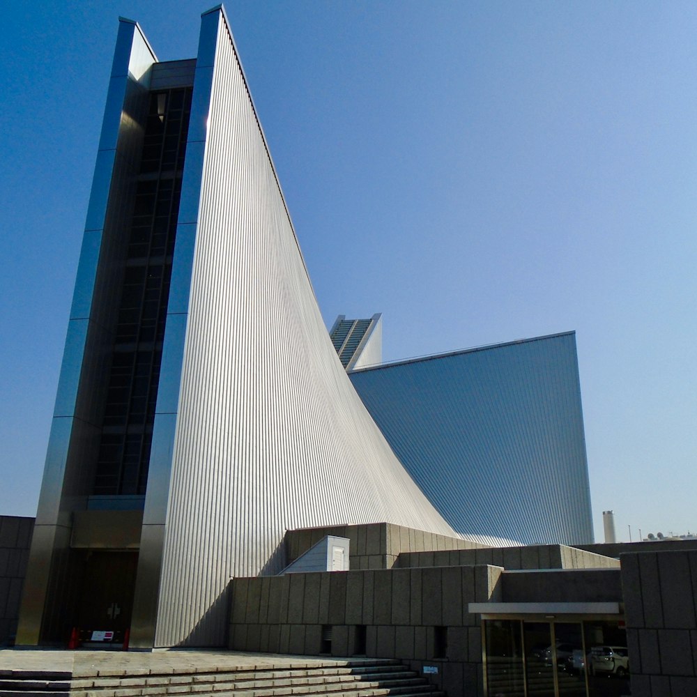 edifício de concreto branco e cinza sob o céu azul durante o dia