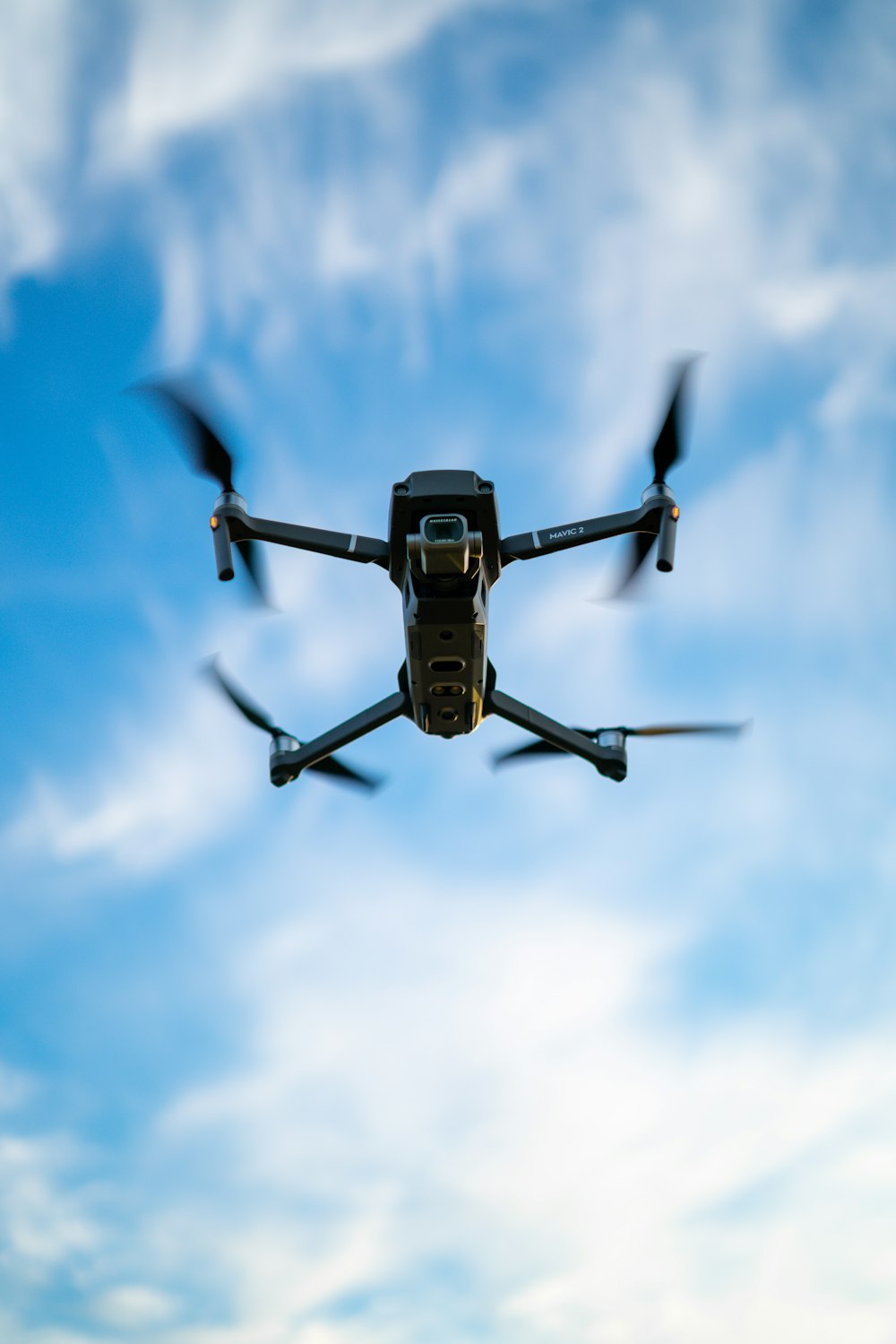 black and white drone flying under blue sky during daytime