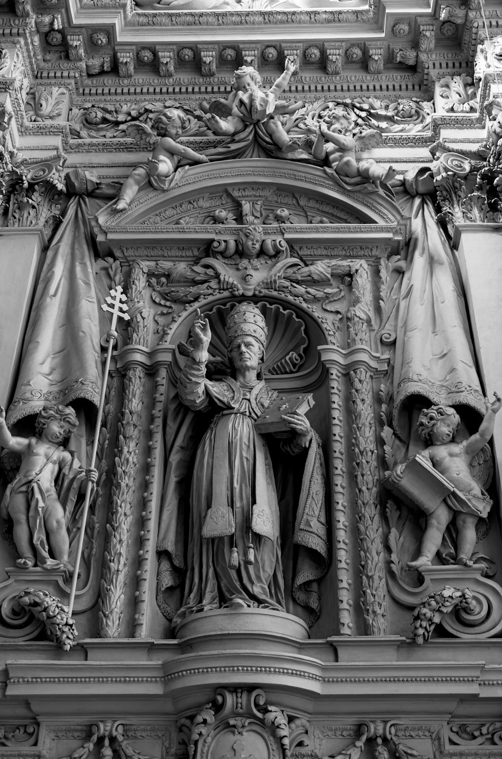 Foto en escala de grises de personas en estatua de oro