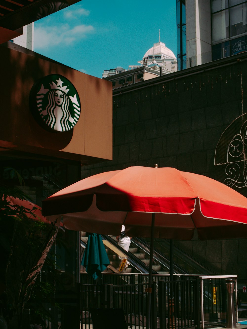 red umbrella near brown building