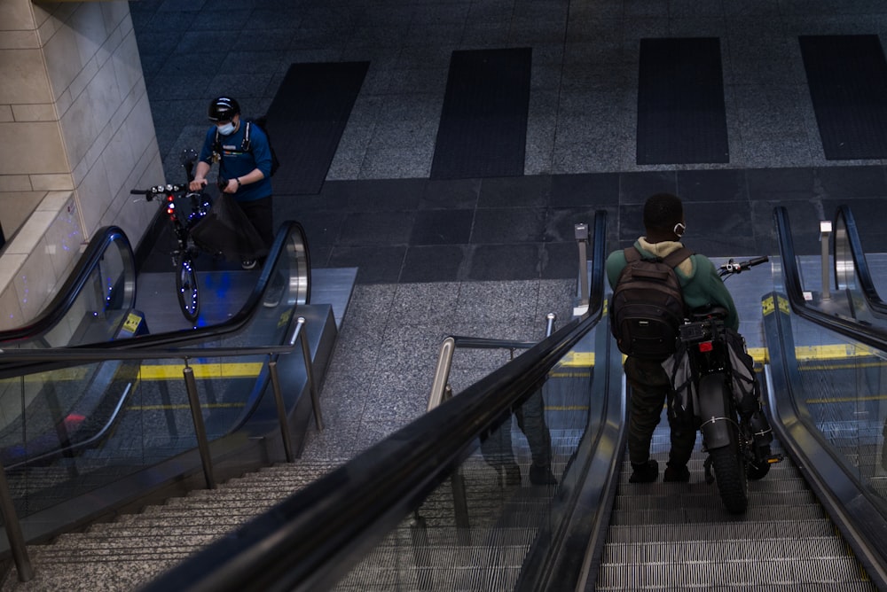 man in black jacket sitting on black escalator