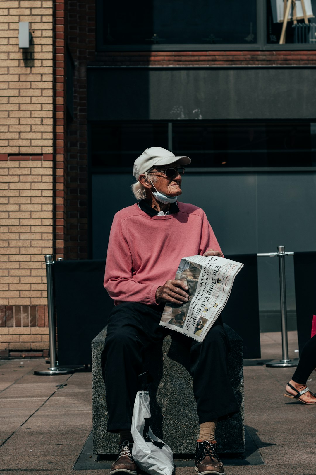 man in red sweater and black pants sitting on black chair