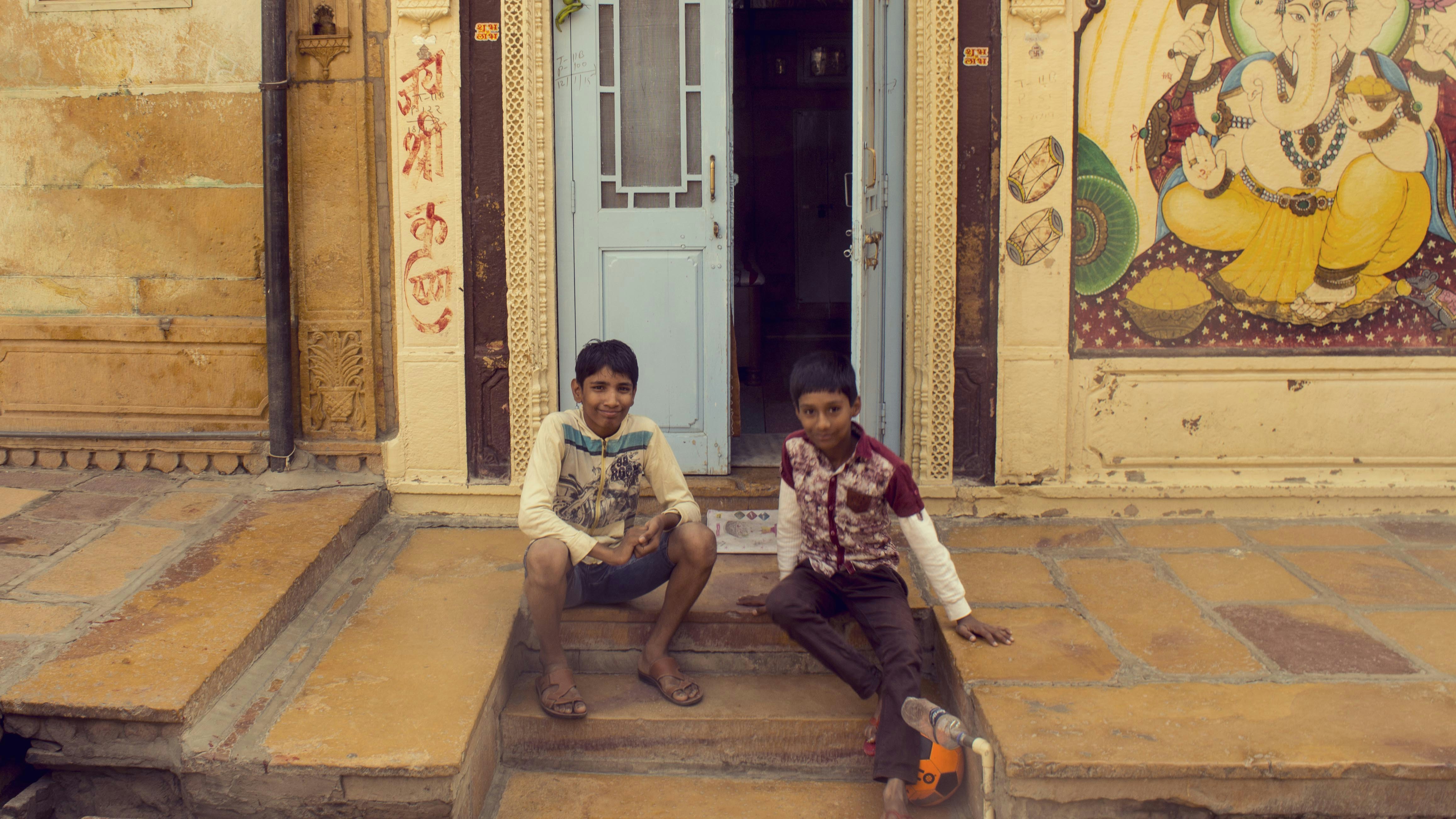 2 women sitting on brown concrete bench