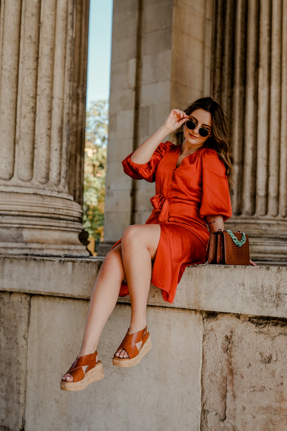 woman in red long sleeve dress sitting on concrete stairs