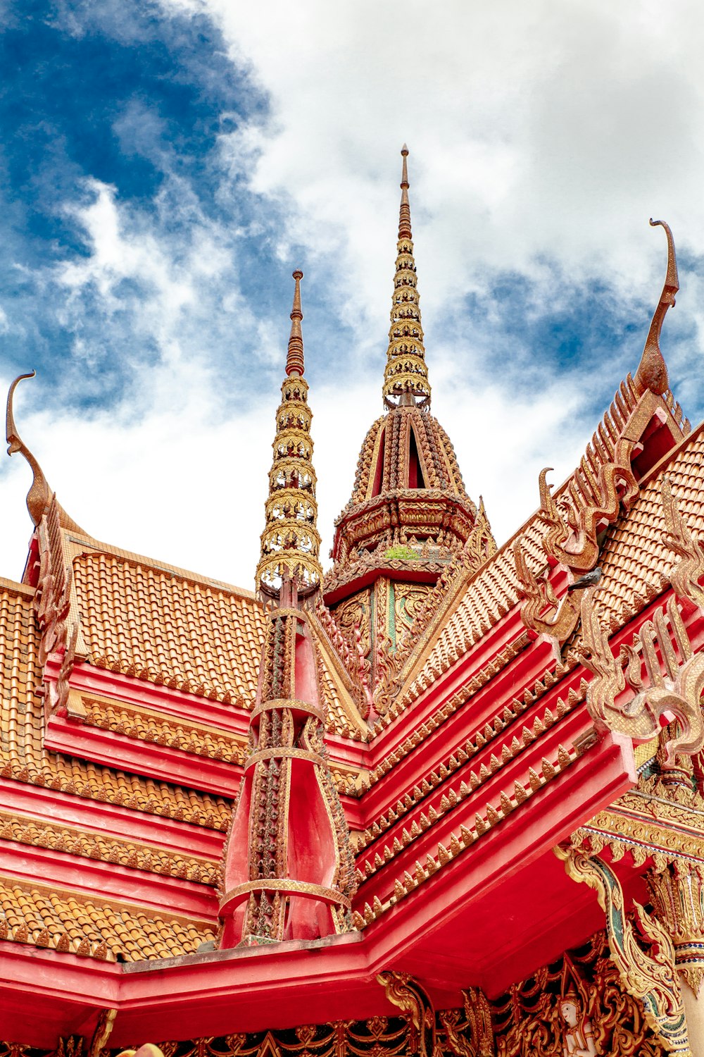 Templo rojo y dorado bajo el cielo nublado durante el día