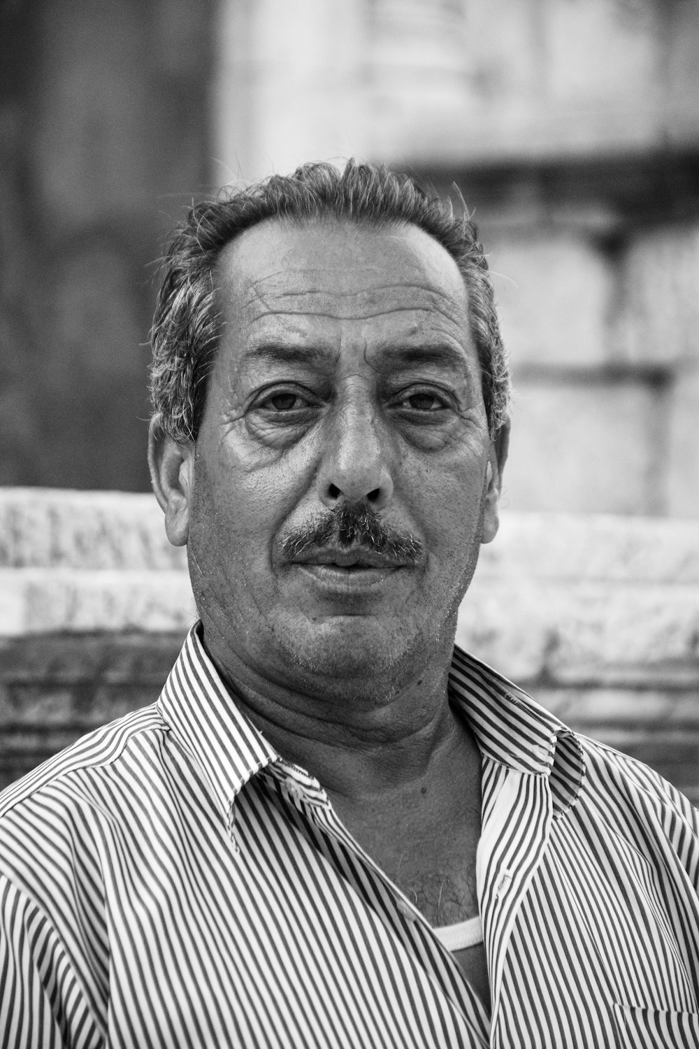 grayscale photo of man in striped shirt