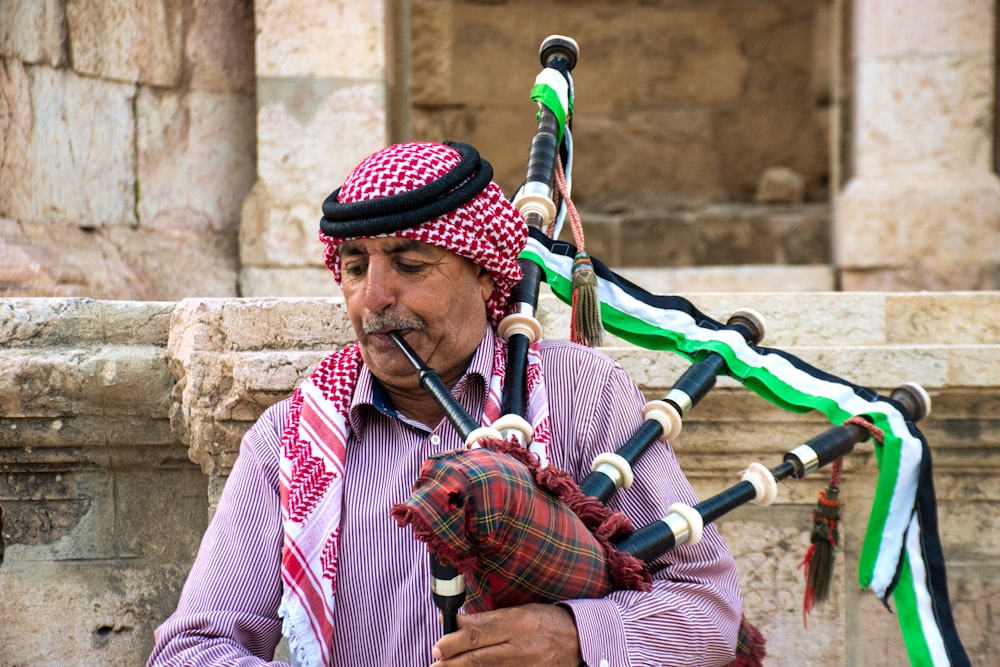 man in red and white long sleeve shirt playing flute