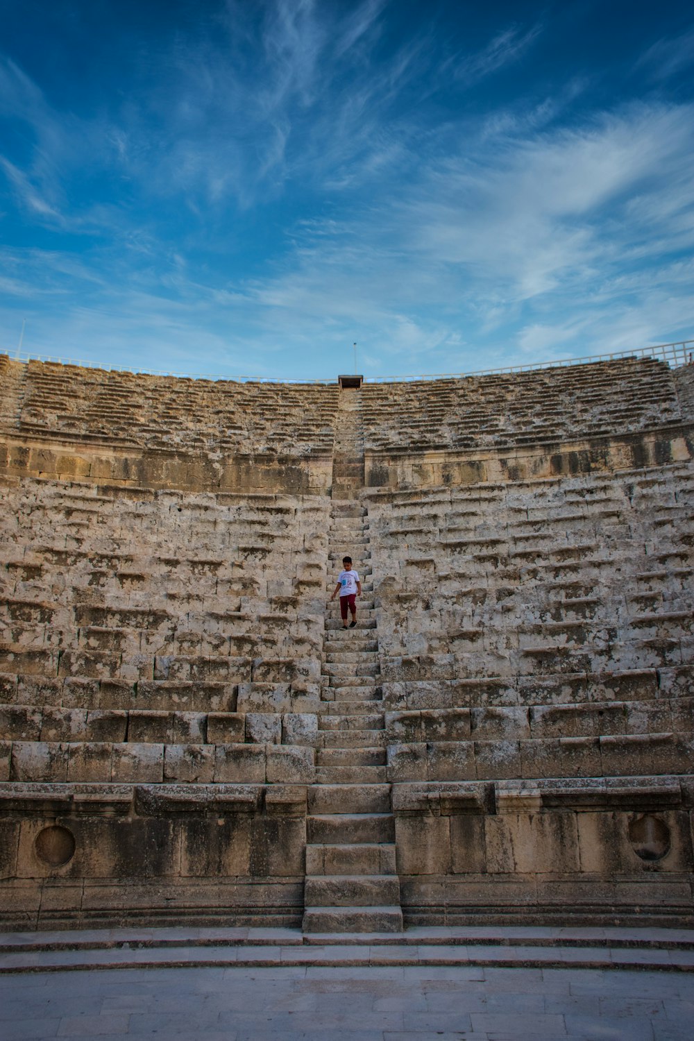 woman in white shirt standing beside brown brick wall during daytime