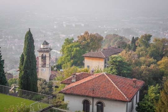 green trees near white concrete building during daytime in Bergamo Italy