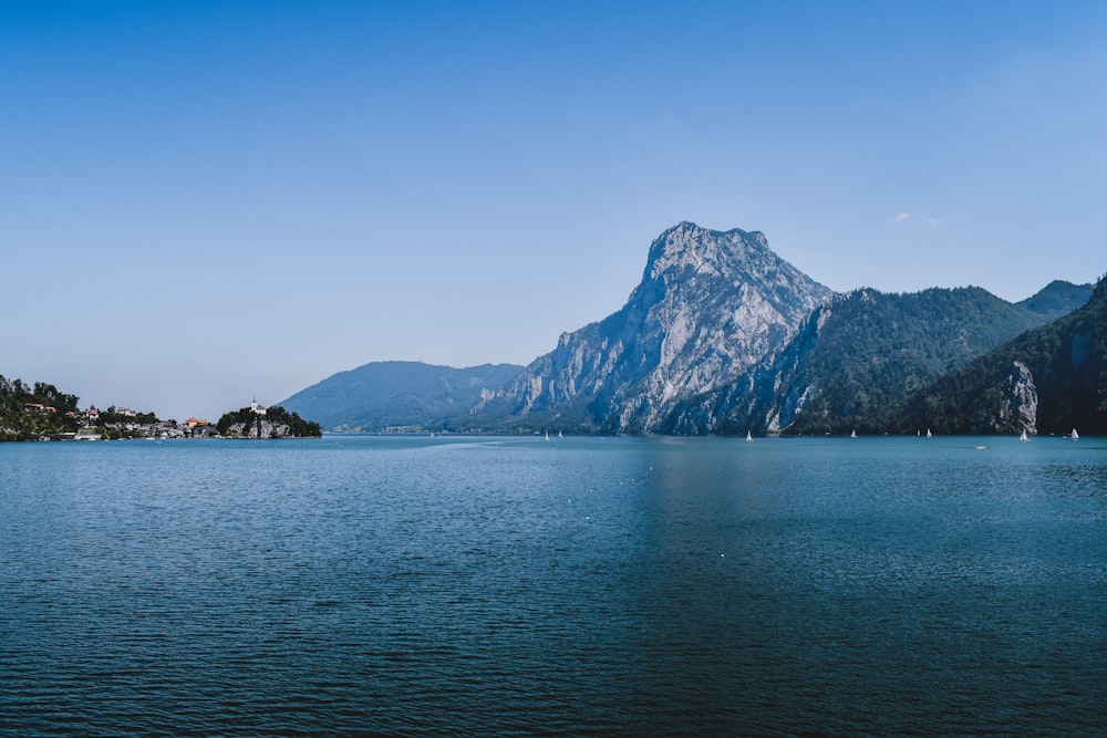 blue sea near mountain under blue sky during daytime