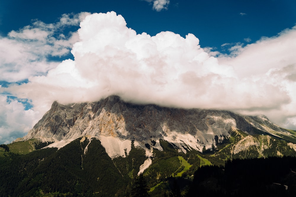 white clouds over green and brown mountain