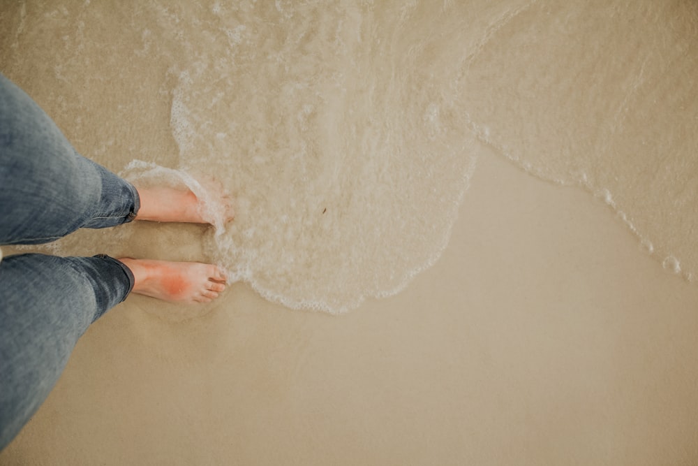 person standing on white sand