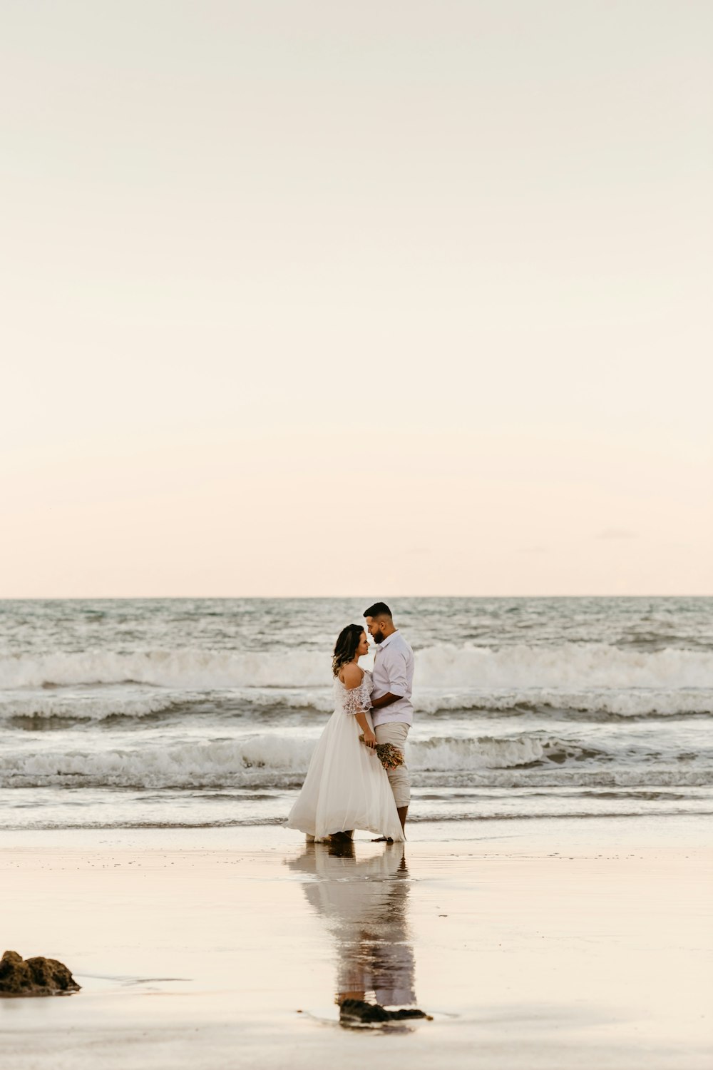Mann und Frau küssen sich tagsüber am Strand