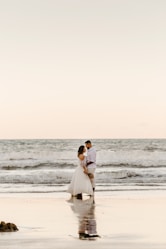 man and woman kissing on beach during daytime
