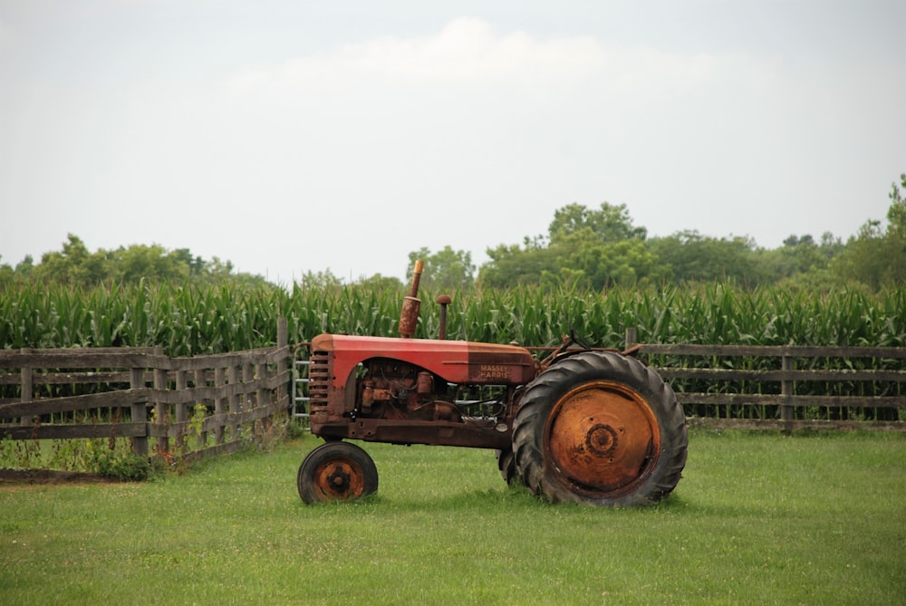 red tractor on green grass field during daytime