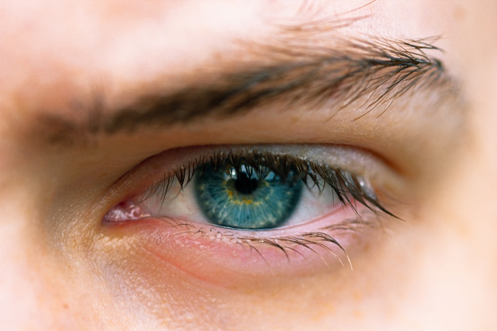 persons blue eyes in close up photography