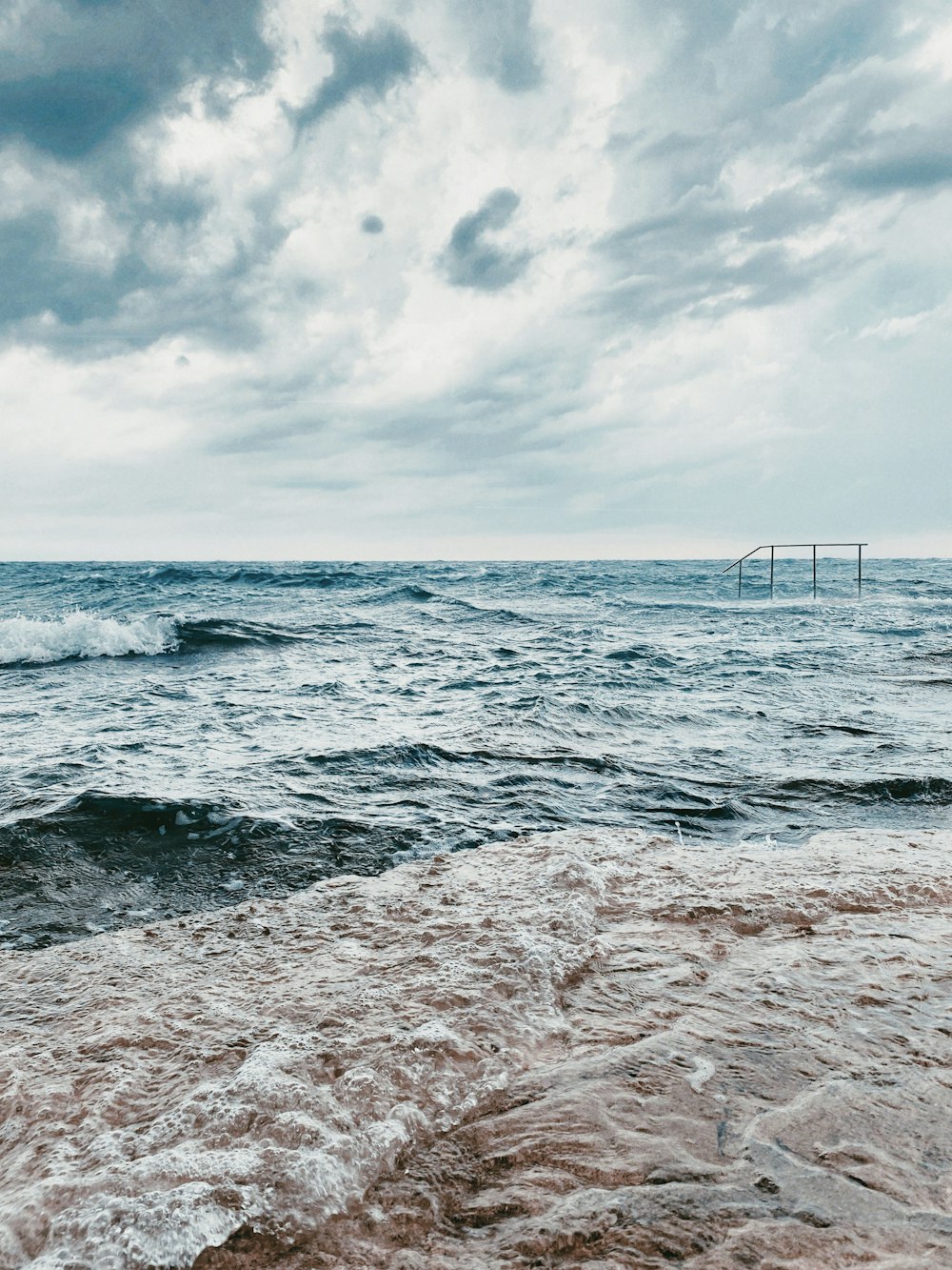 Meereswellen, die tagsüber am Strandufer zusammenbrechen