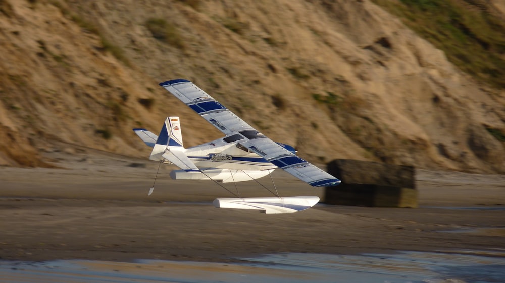 white and blue airplane on brown field during daytime