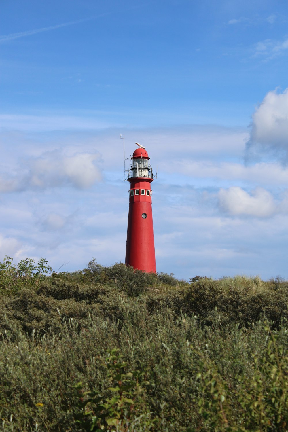 red and white lighthouse under blue sky during daytime