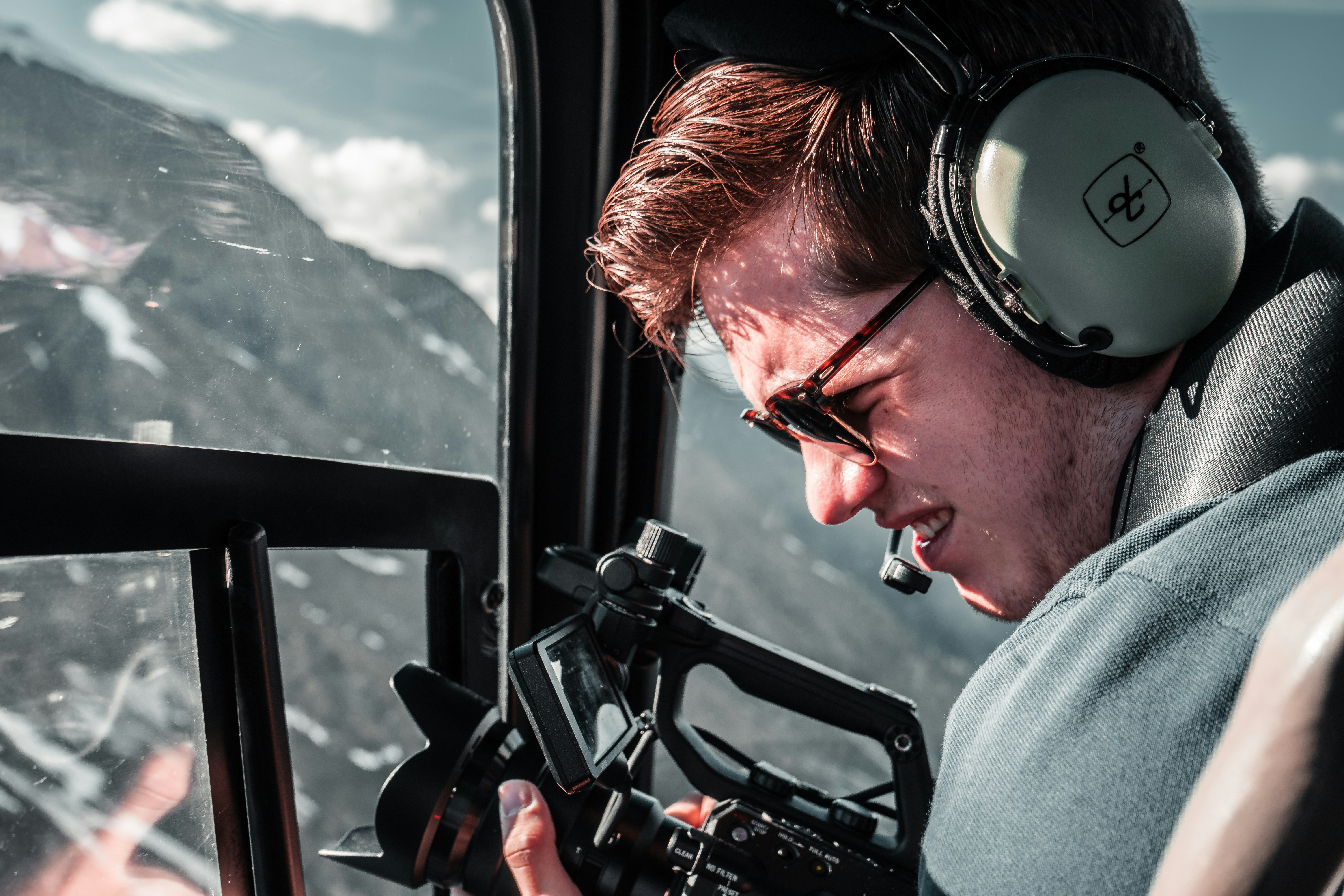 man in gray shirt holding black video camera