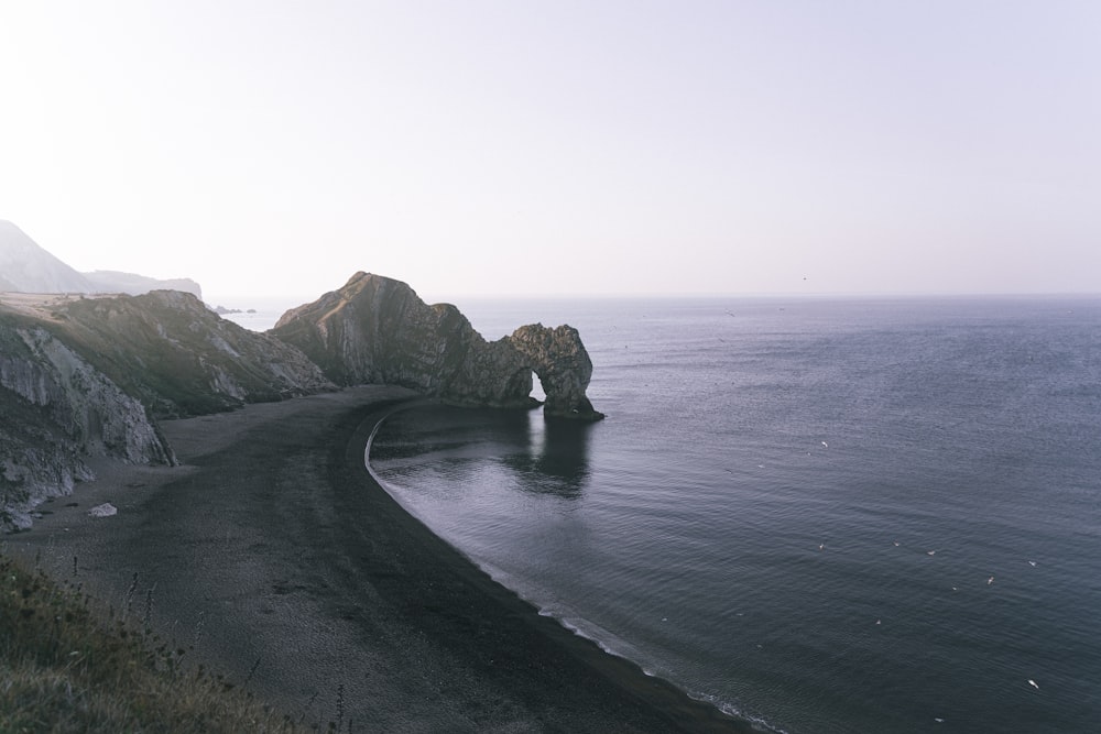 body of water near mountain during daytime