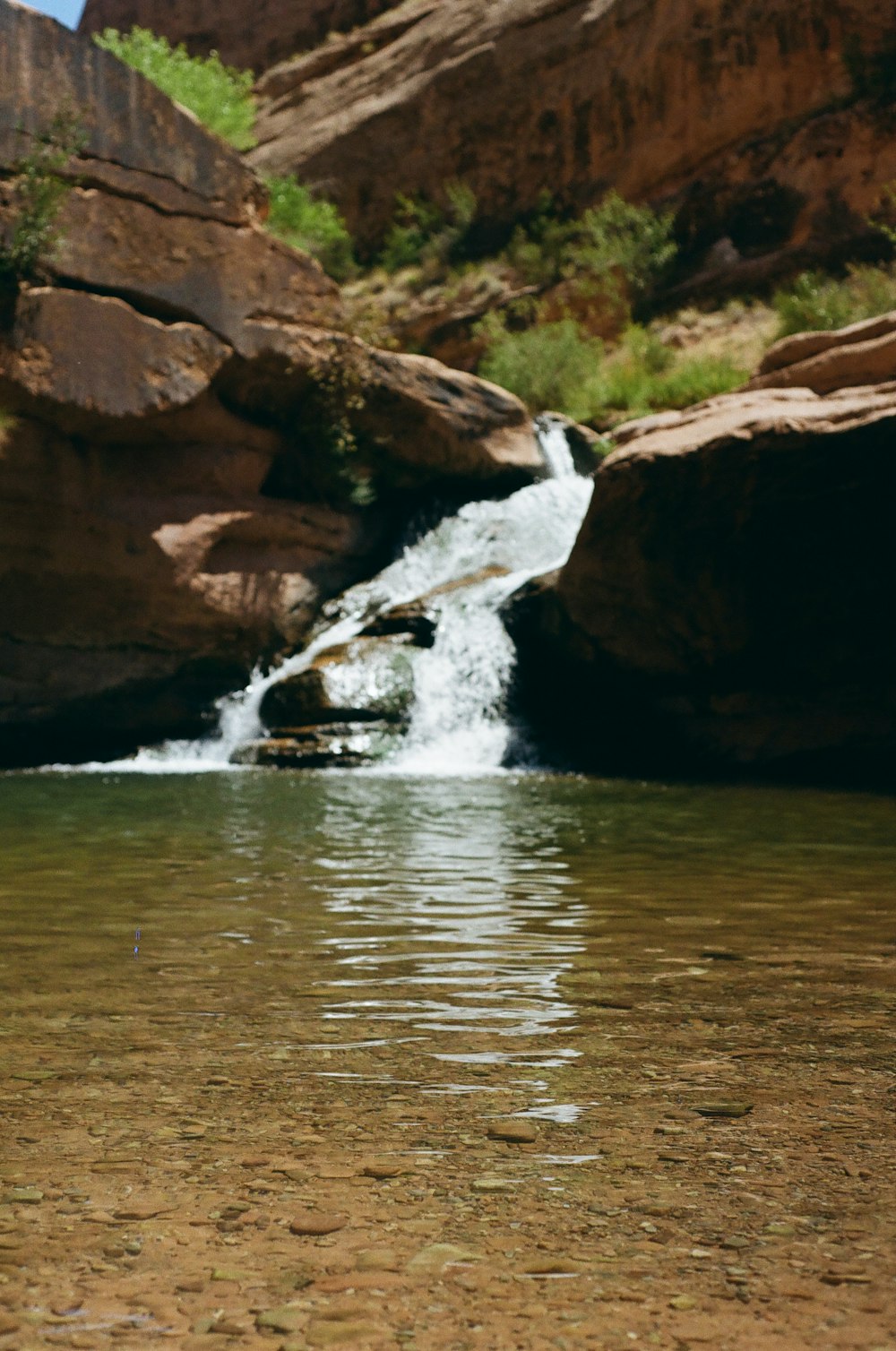 water falls on brown rocky mountain during daytime