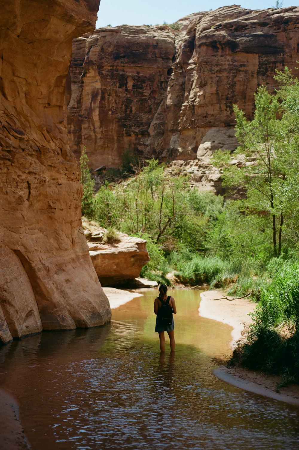 man in black shirt walking on river during daytime