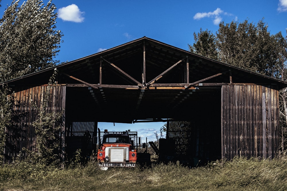 red and white truck near brown wooden building during daytime