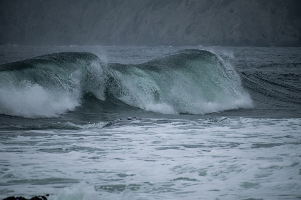 sea waves crashing on shore during daytime