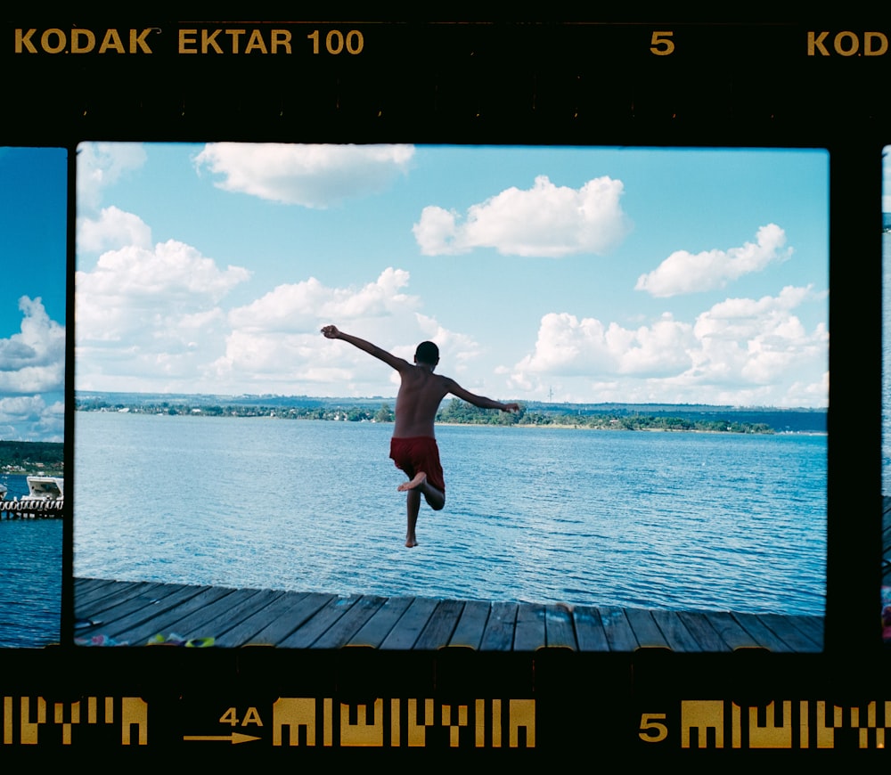 man in black shorts jumping on sea during daytime