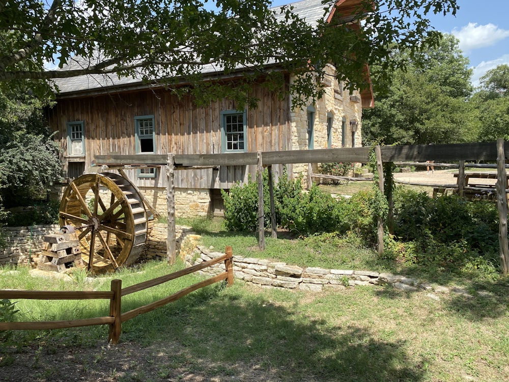 brown wooden wheel near brown wooden fence