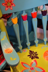 A vintage wooden chair freshly painted in soft pastel blue with delicate floral accents.